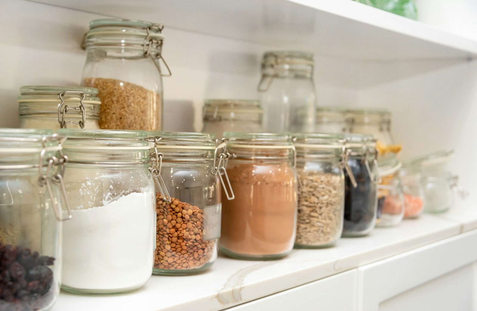 Desi Pantry Staples Spain - row of airtight jars filled with rice, daal and grains